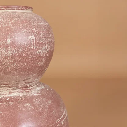 Closeup of rustic pink terracotta decorative vase showing detailed distressed texture and handcrafted style for modern artistic home decor.