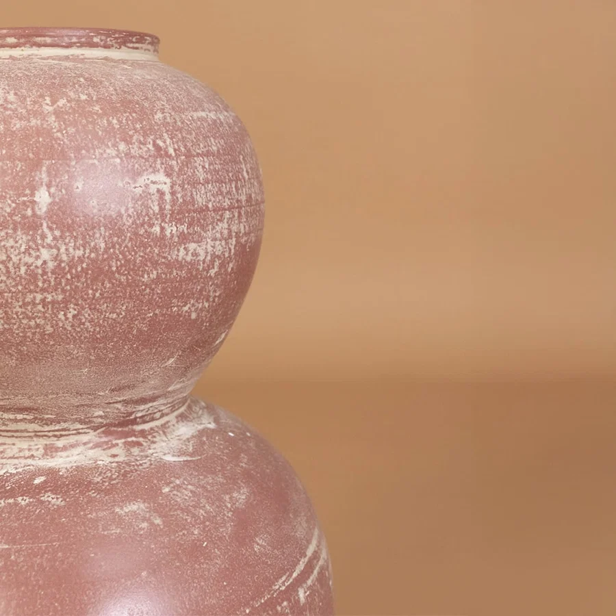 Closeup of rustic pink terracotta decorative vase showing detailed distressed texture and handcrafted style for modern artistic home decor.