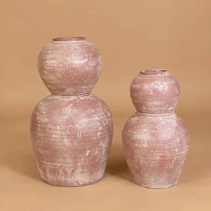Rustic pink terracotta decorative vase displayed with coordinated decor pieces creating a warm grouped arrangement for modern home interiors.