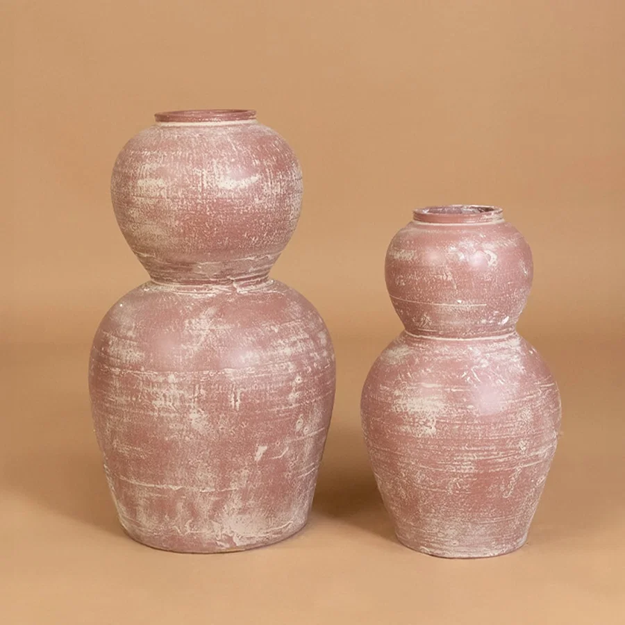 Rustic pink terracotta decorative vase displayed with coordinated decor pieces creating a warm grouped arrangement for modern home interiors.