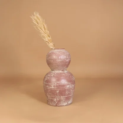 Rustic pink terracotta decorative vase placed in a styled interior adding earthy artistic decor to shelves consoles and contemporary living spaces.