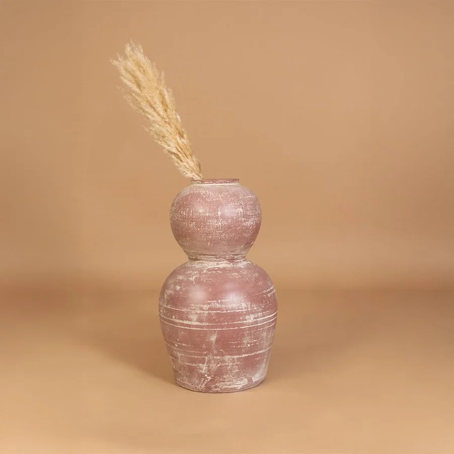 Rustic pink terracotta decorative vase placed in a styled interior adding earthy artistic decor to shelves consoles and contemporary living spaces.