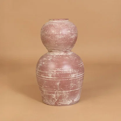 Decorative ceramic vase in pink finish with textured surface for table decor or shelf styling modern home placement neutral background.