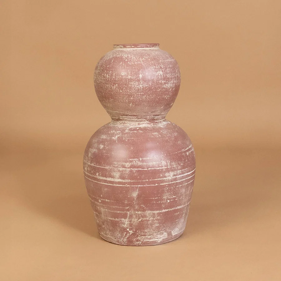 Decorative ceramic vase in pink finish with textured surface for table decor or shelf styling modern home placement neutral background.