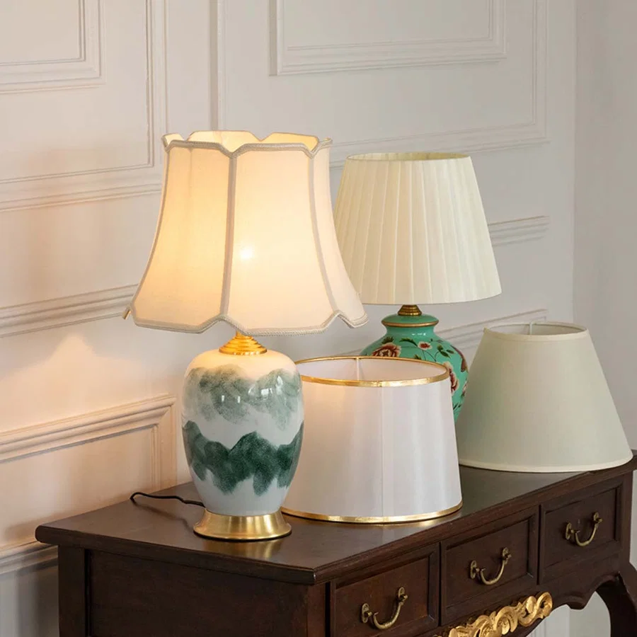Marble effect ceramic table lamp with fabric shade displayed on a wooden console table creating elegant ambient lighting.