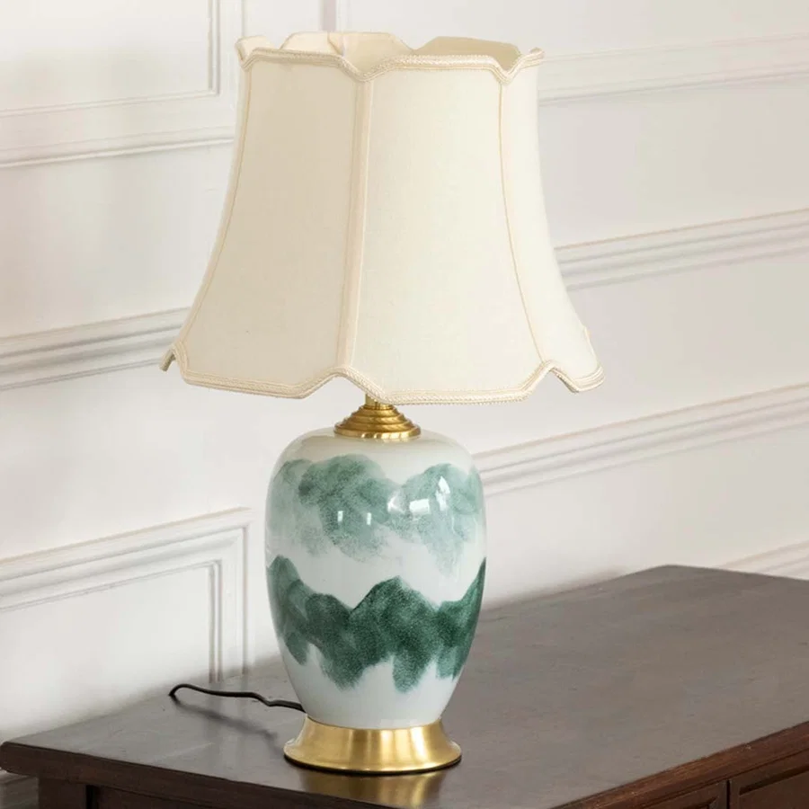 Unlit ceramic table lamp with gold base and cream shade highlights its blue abstract design making a stylish addition to contemporary spaces.