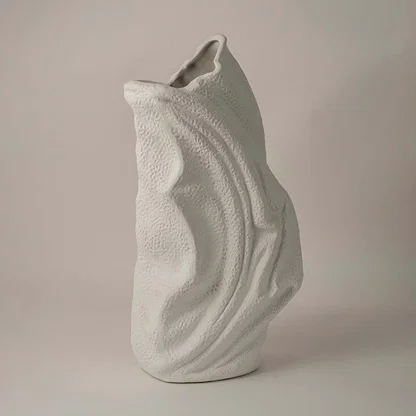 Side angle view of white ceramic decorative vase with sculptural wave texture ideal for living room or hallway decor.