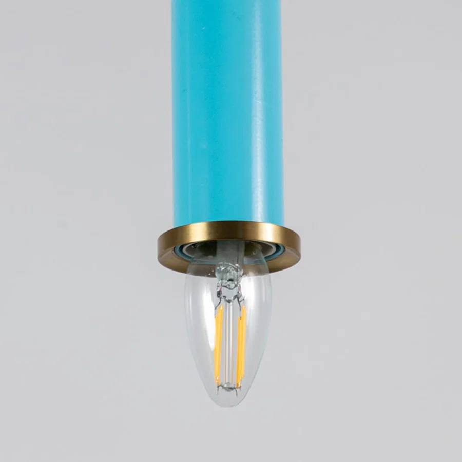 Blue metal pendant light with brass detailing showcasing sleek cylindrical form and modern Scandinavian style appeal.