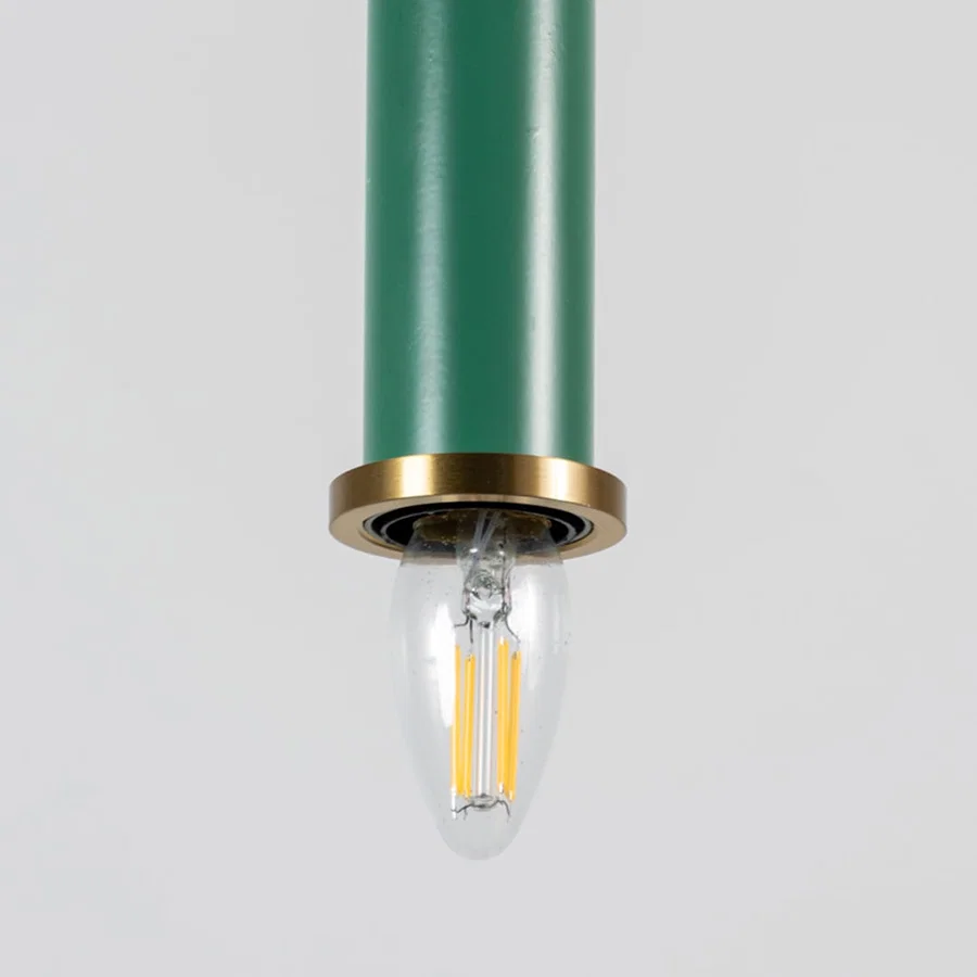 Green metal pendant light with brass detailing showcasing sleek cylindrical form and modern Scandinavian style appeal.