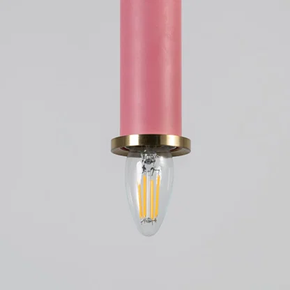 Pink metal pendant light with brass detailing showcasing sleek cylindrical form and modern Scandinavian style appeal.