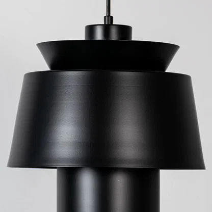 Black metal pendant light featuring layered sculptural form and matte finish showcasing refined modern craftsmanship.