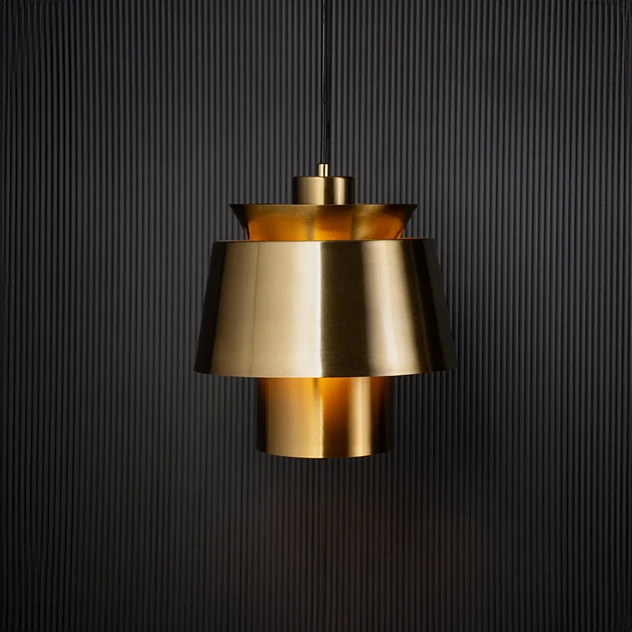 Contemporary gold pendant light turned on with black background for home lighting.