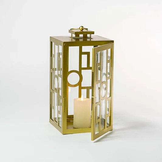 Decorative gold metal lantern with clear glass panels for luxury indoor tabletop decor styling.