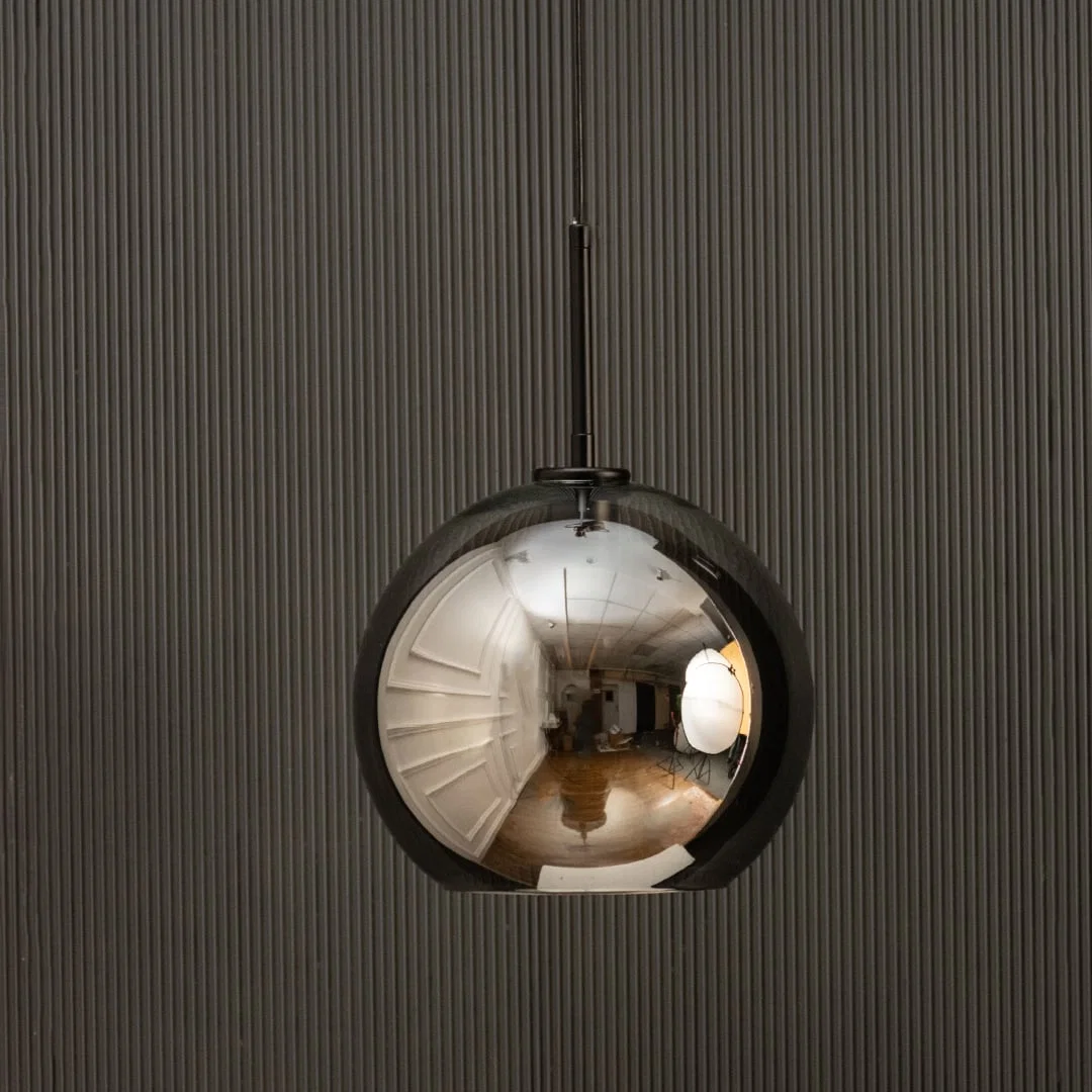 Smoked glass globe pendant light with black suspension sleek modern ceiling lamp perfect for dining and luxury living interiors.