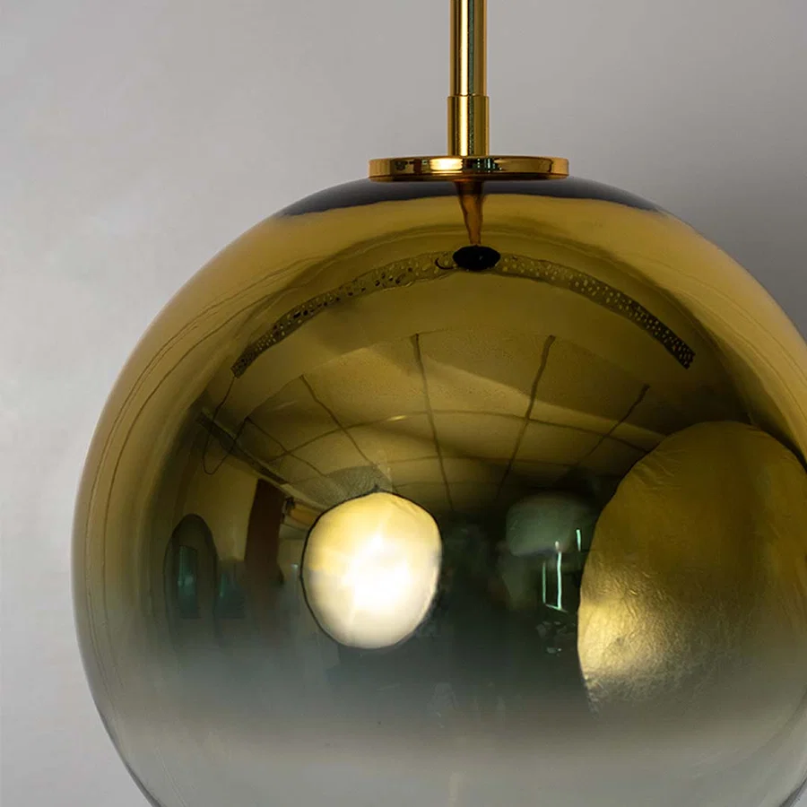 Closeup of polished gold glass pendant light showcasing luxurious reflection and premium craftsmanship.