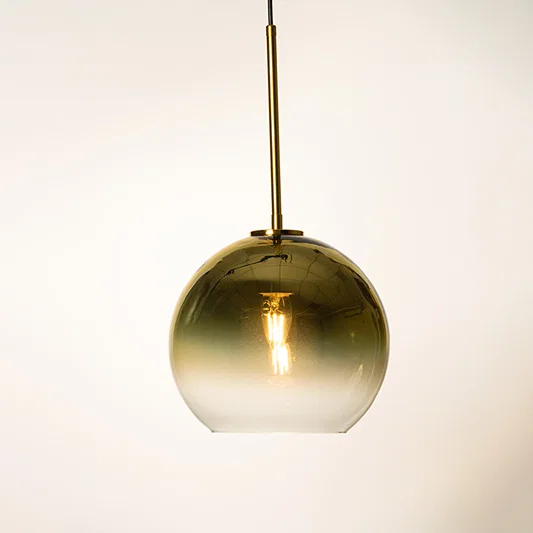 Gold metallic dome pendant light with smooth finish and hanging cord placed against neutral wall background highlighting elegant contemporary lighting design.