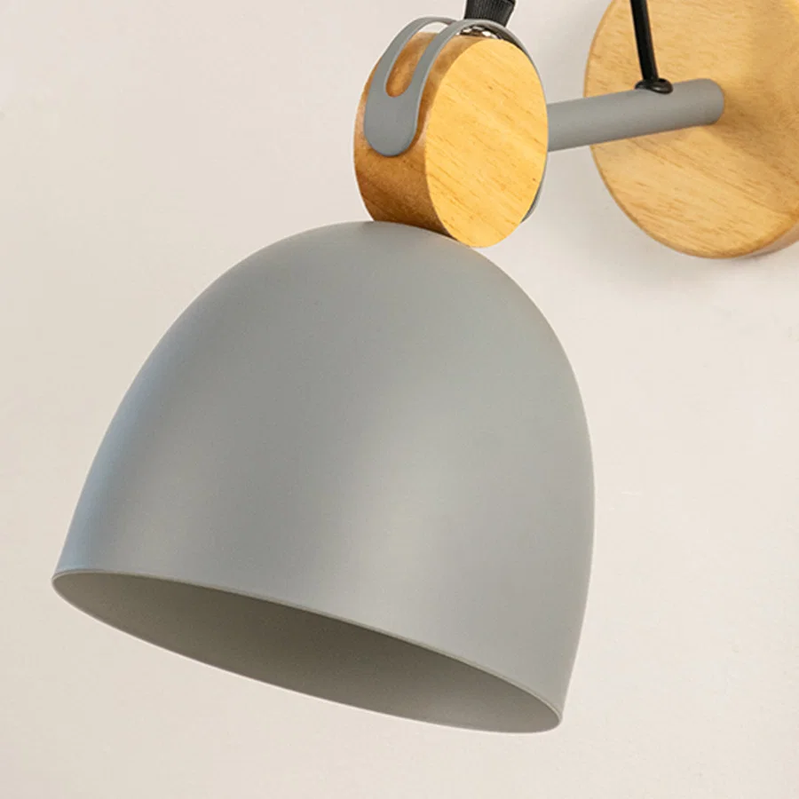Closeup of grey metal wall light shade with wooden mount showing smooth finish and modern design for interior wall decor styling.