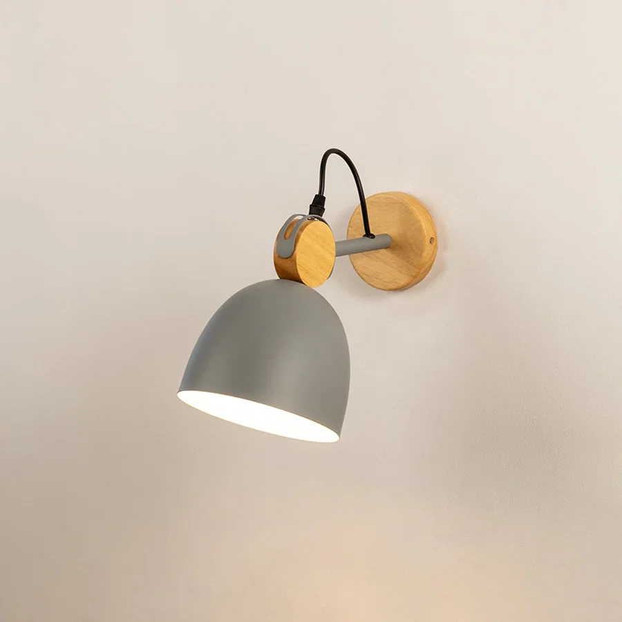 Nordic matte grey and natural wood dome wall sconce turned on against a plain off white background surface wall.