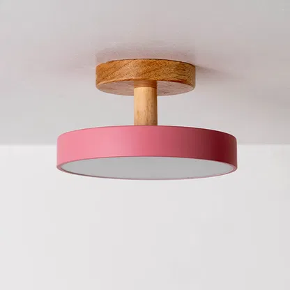Ceiling light displayed off on a plain white background highlighting the wooden mount and pink shade in a minimal modern design.