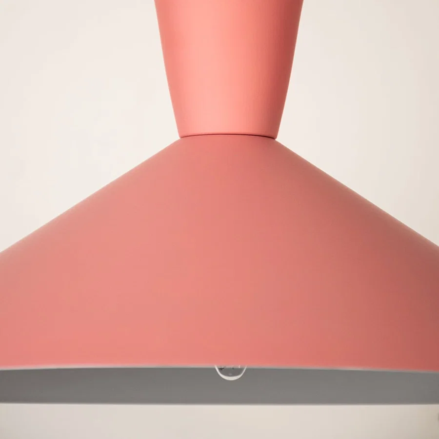 Pink metal pendant light illuminated to showcase modern ceiling lighting with stylish contemporary decorative appeal.
