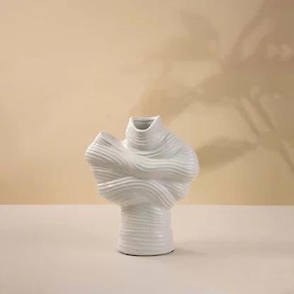 White ceramic decorative vase with sculptural twisted top design for elegant tabletop styling and modern home decor.