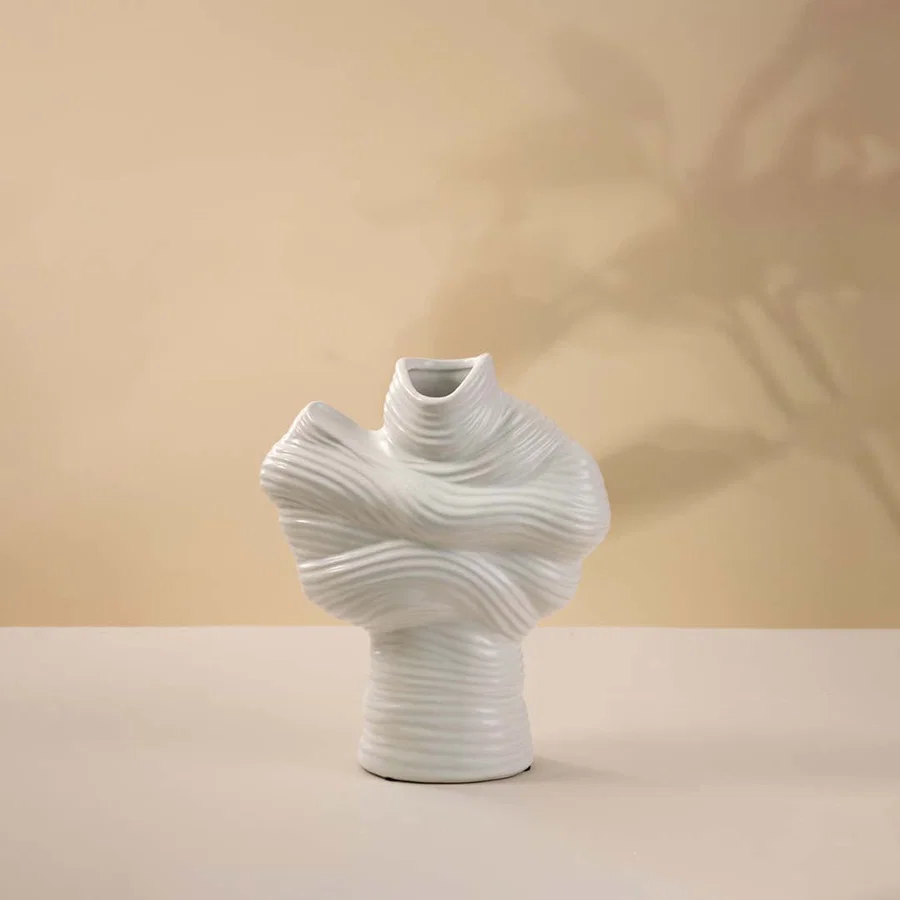 White ceramic decorative vase with sculptural twisted top design for elegant tabletop styling and modern home decor.