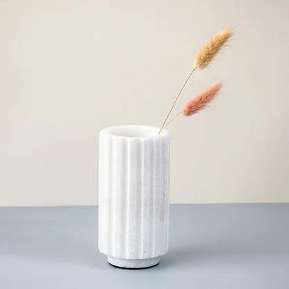 White marble vase with fluted design styled with dried stems ideal for modern living room table decor and floral arrangements.