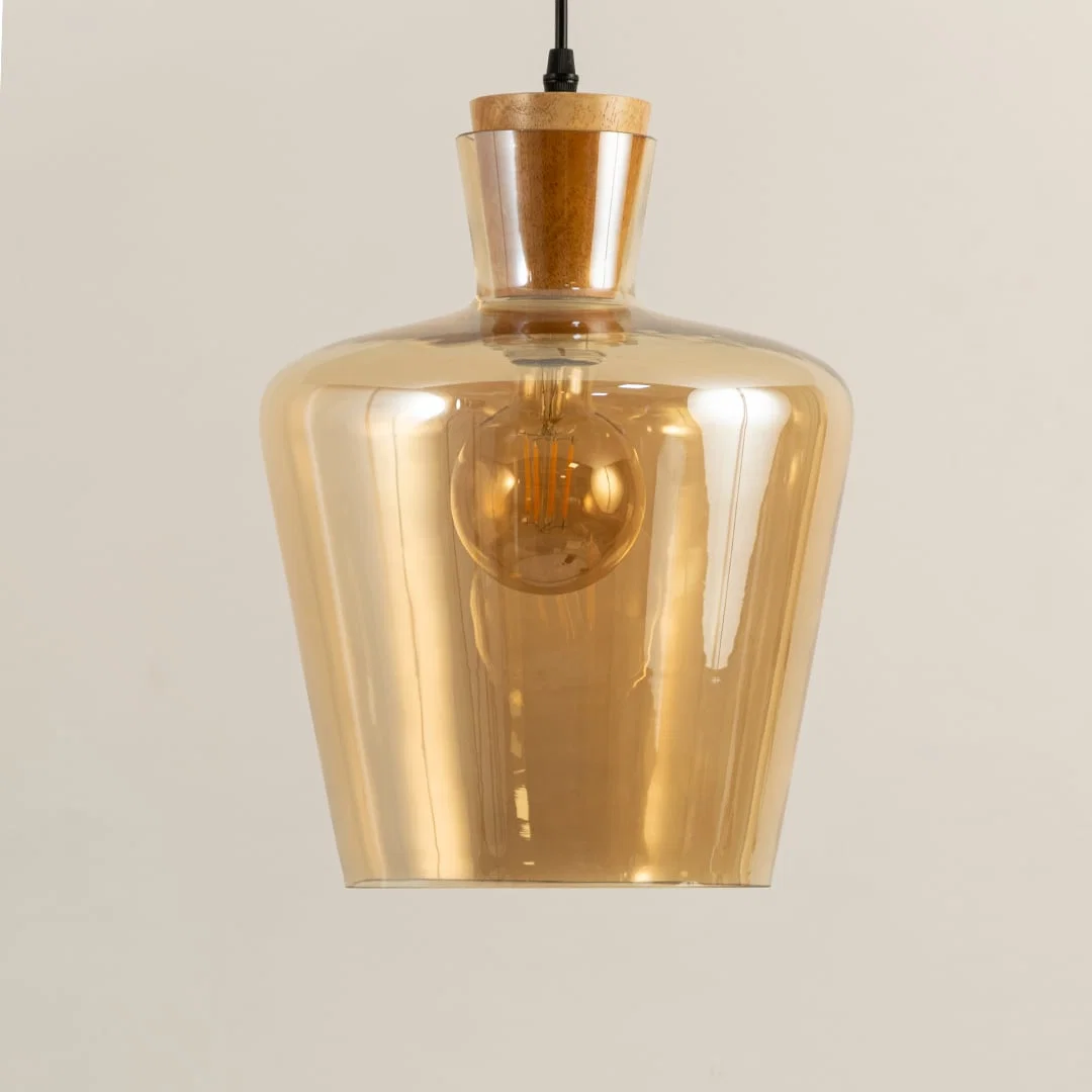 Closeup of amber glass and brass metal pendant light showcasing refined texture and craftsmanship.
