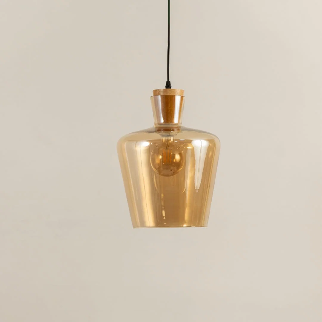 Amber glass and brass metal pendant light with warm glow for elegant modern home decor spaces.