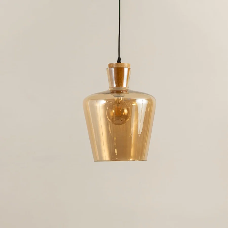 Amber glass and brass metal pendant light with warm glow for elegant modern home decor spaces.