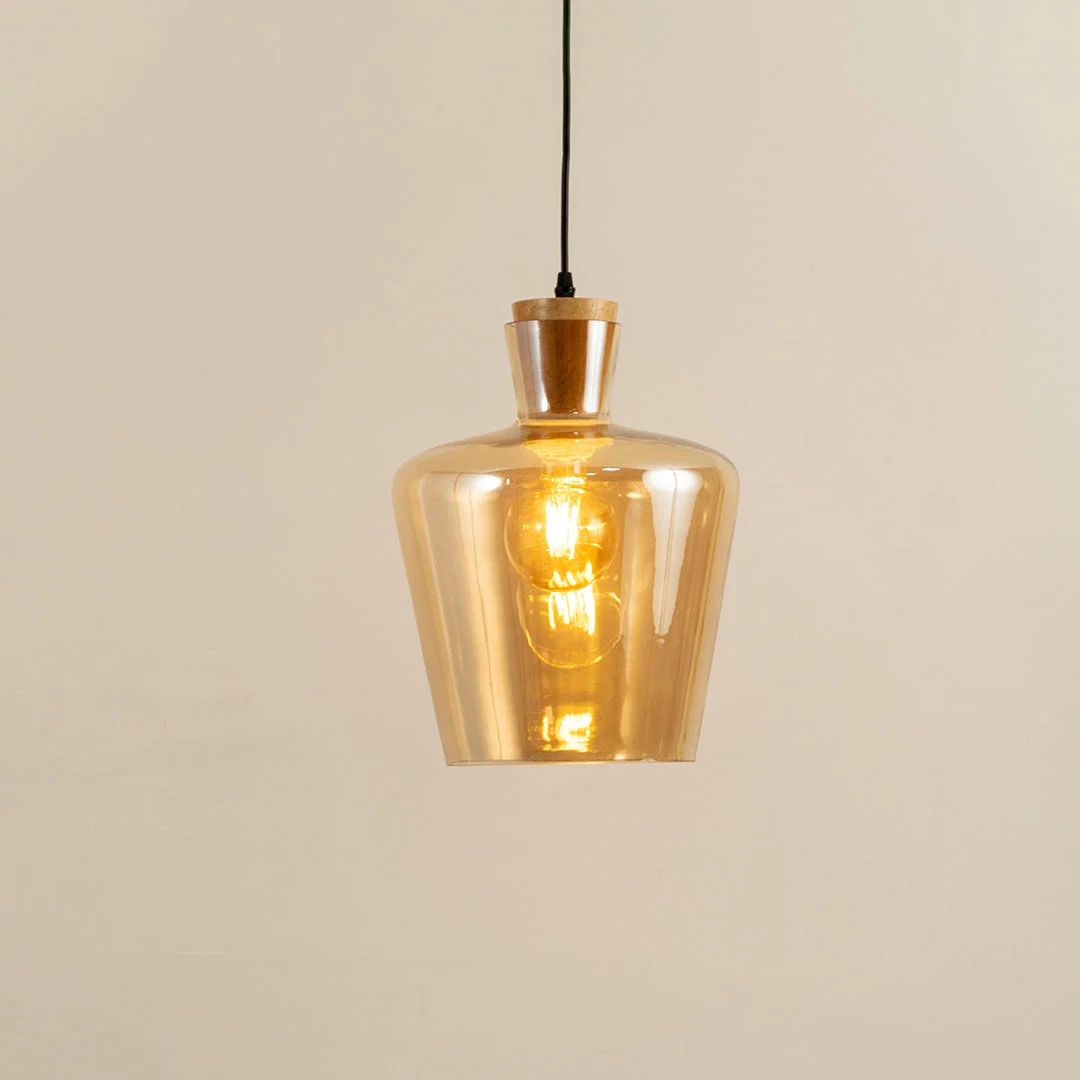 Amber glass and brass metal pendant light with warm glow for elegant home decor spaces.