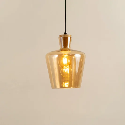 Amber glass and brass metal pendant light with warm glow for elegant home decor spaces.