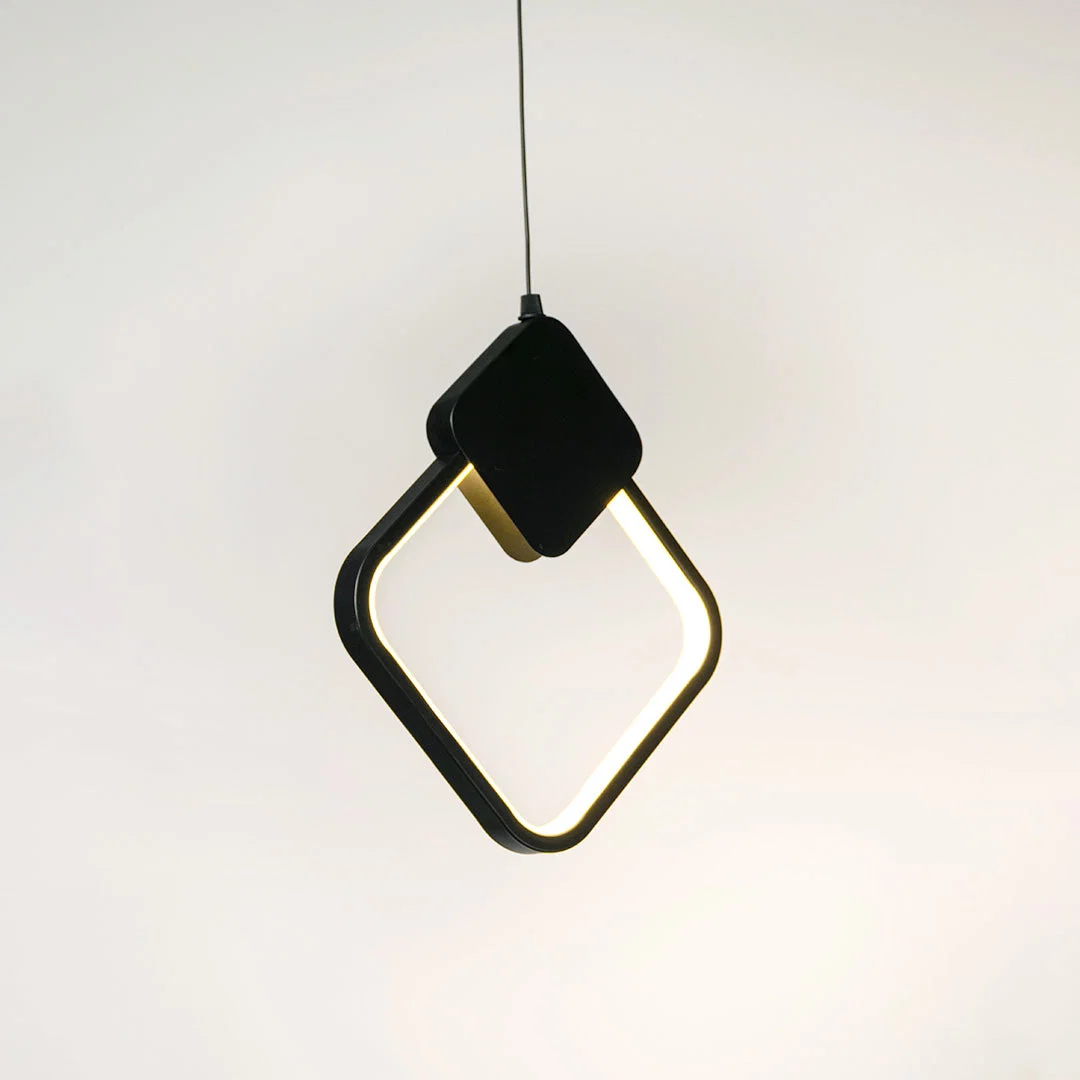 Black geometric pendant light with angular frame and hanging cord placed against neutral wall background highlighting modern artistic lighting design.