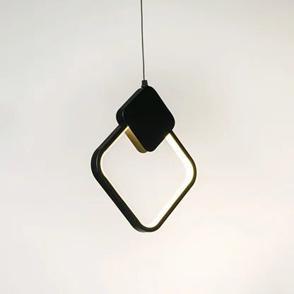 Black geometric pendant light with angular frame and hanging cord placed against neutral wall background highlighting modern artistic lighting design.