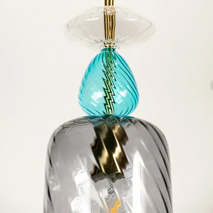 Blue and smoked glass pendant light featuring twisted textured glass and decorative crystal accents for luxury interiors.