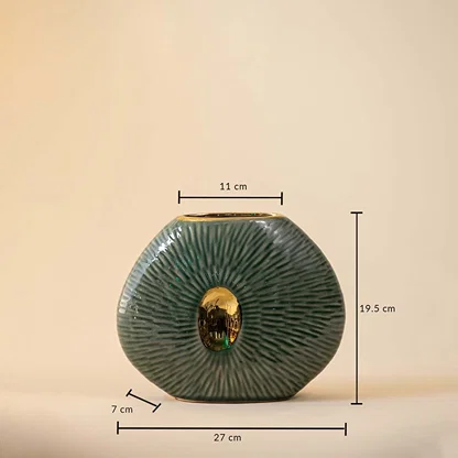 Dimension image of flat oval green ceramic pebble vase with radiating etched lines and a gold center cutout accent 19.5 cm height and 17 cm width.