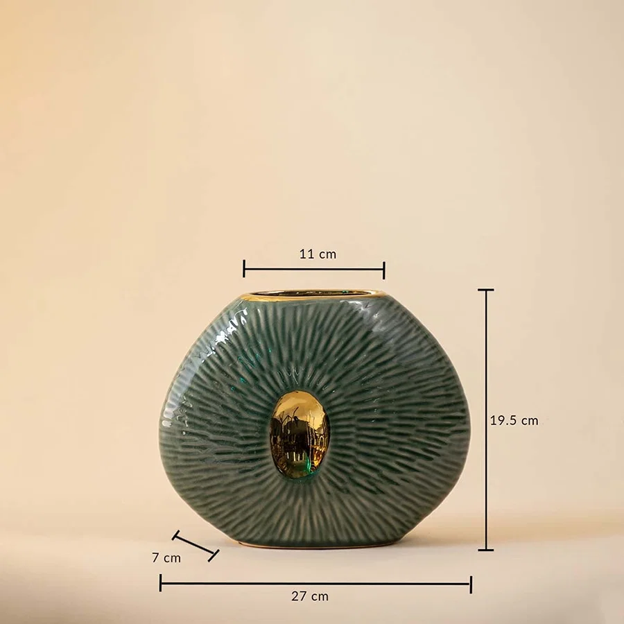 Dimension image of flat oval green ceramic pebble vase with radiating etched lines and a gold center cutout accent 19.5 cm height and 17 cm width.