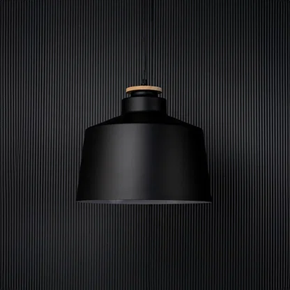A contemporary black pendant light captured on a black background with the light off emphasising its bold structure and sleek matte finish in a minimalist setting.