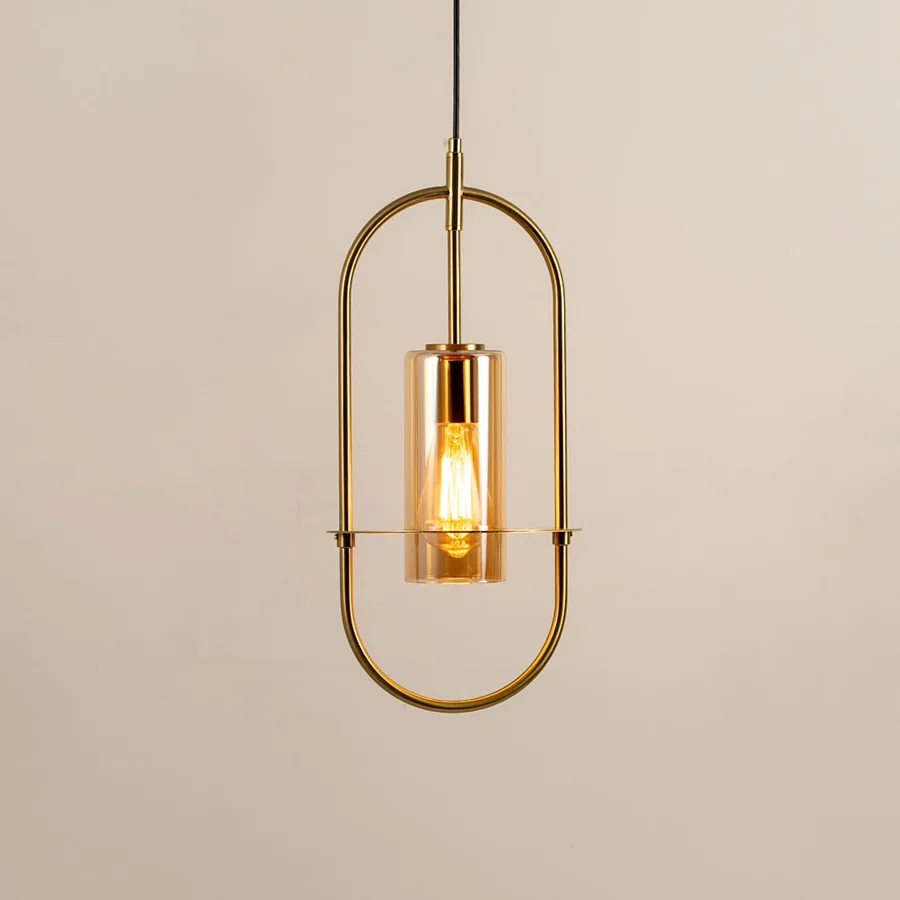 Gold metal wall light with clear glass shade illuminated to showcase elegant modern wall lighting design.