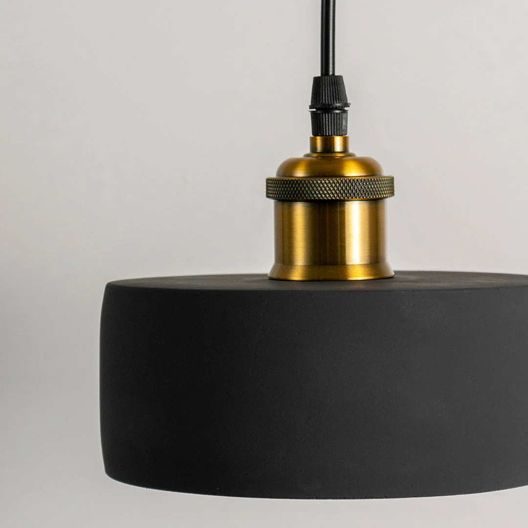 Closeup of black metal pendant light with polished gold fittings showcasing premium craftsmanship.