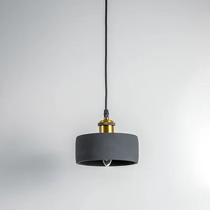 Black metal pendant light with gold accents and flat drum shade crafted for modern living spaces.