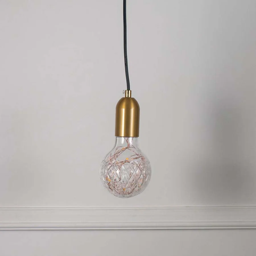 Decorative clear glass pendant light with brass accents and artistic wire detailing for stylish spaces.