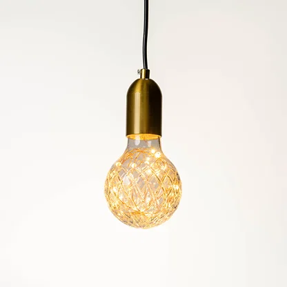 Decorative pendant light with textured glass bulb and gold holder hanging against neutral wall background showcasing elegant modern lighting decor styling.