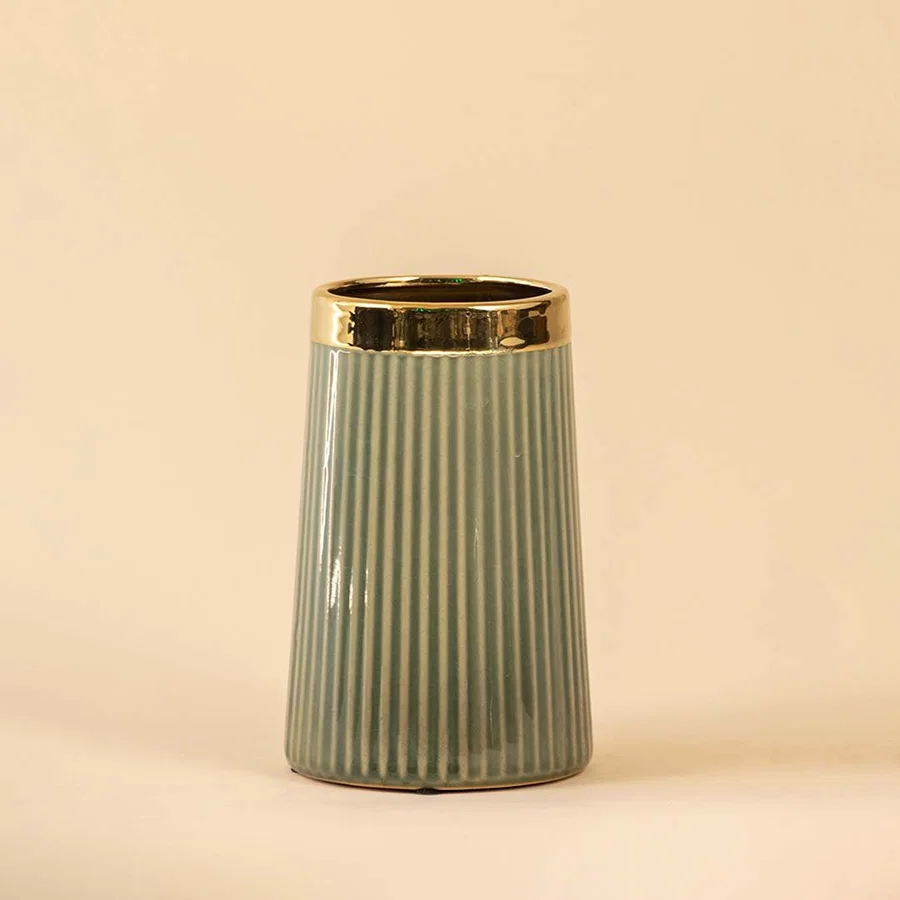 Sage green ceramic decorative vase with gold rim and fluted design for contemporary shelf styling and home decor.