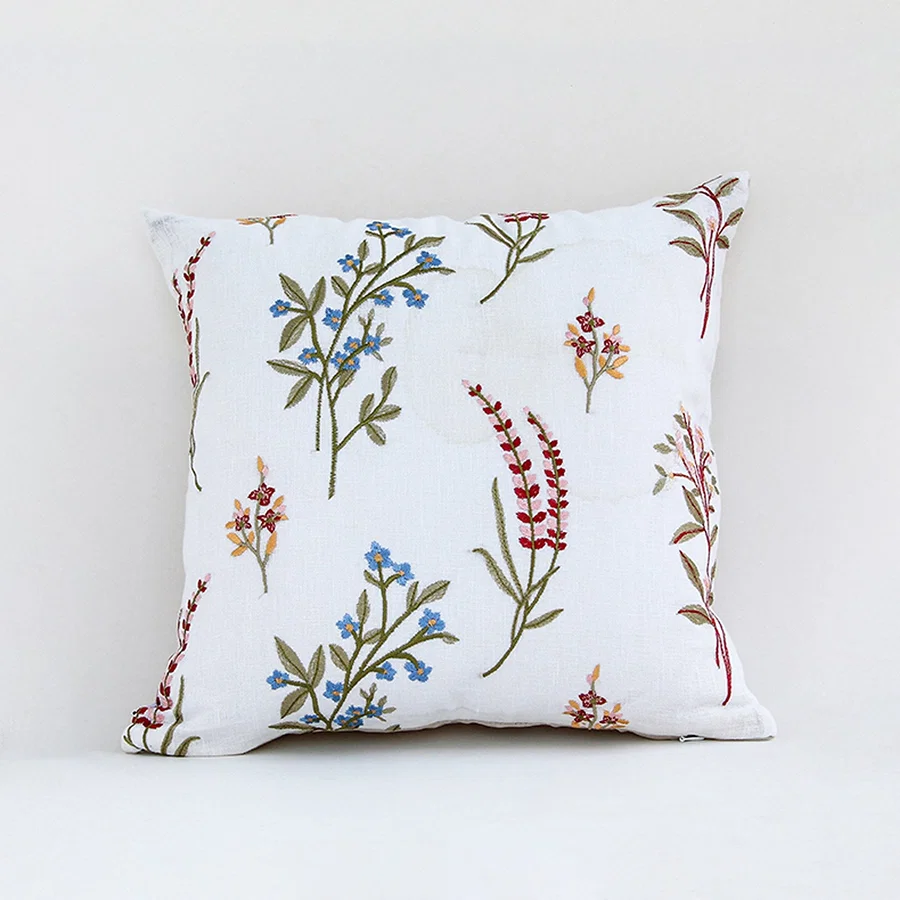 White cotton cushion cover with colorful botanical leaf print for sofa bedroom seating and elegant home decor styling.