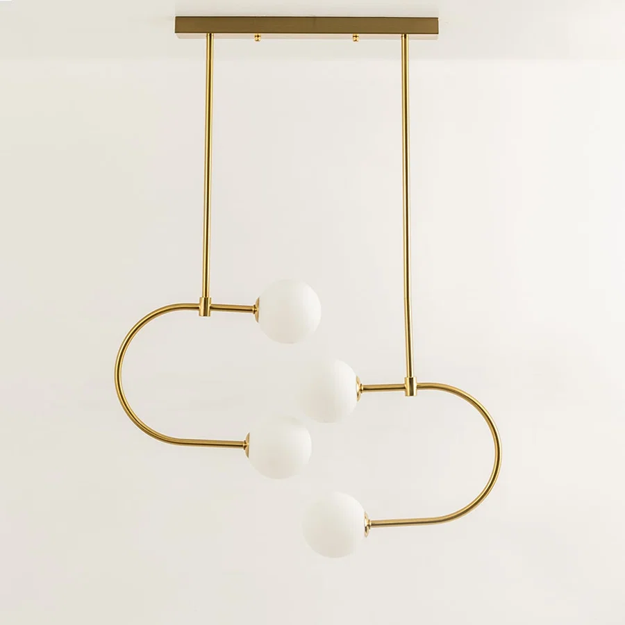Gold metal pendant light with white glass globes illuminated to showcase modern decorative ceiling lighting elegance.