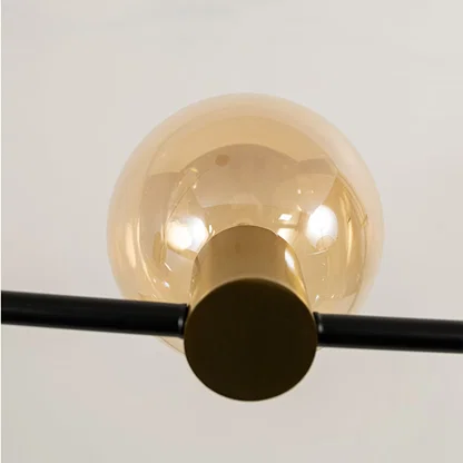 Close view of amber glass chandelier showing sleek black rod polished fittings and smooth glass globes for modern indoor decor.