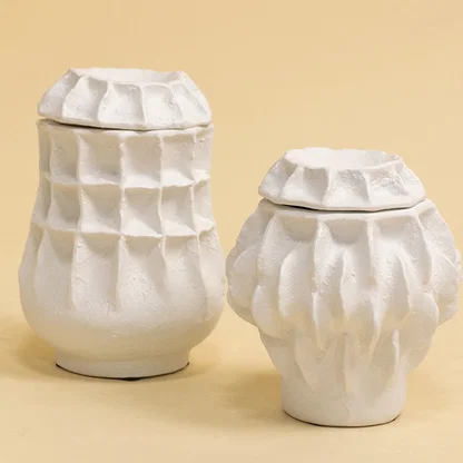 Set of white sculptural vases in modern organic shapes arranged together for a refined artistic decor display.