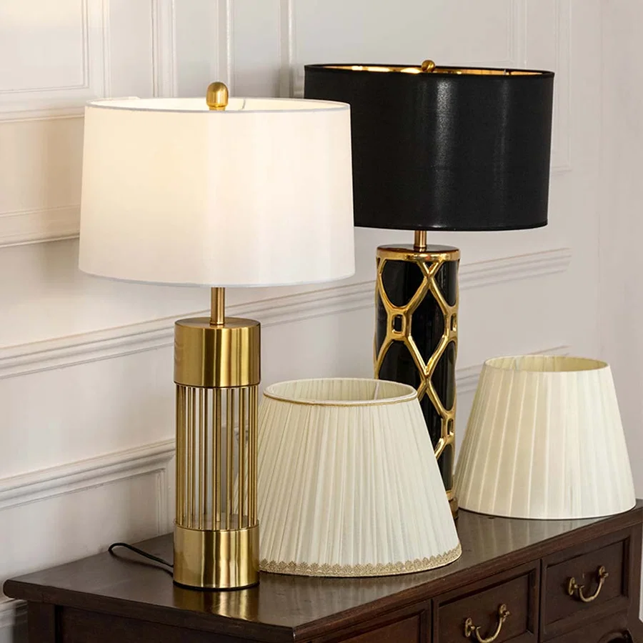White shade gold metal table lamp on wooden sideboard with light off beside black lamp for modern luxury décor styling.