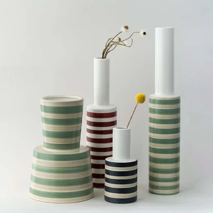 A slim striped vase shown in a clean styling setup highlighting its modern form and soft green pattern making it ideal for grouping with contemporary decor pieces.